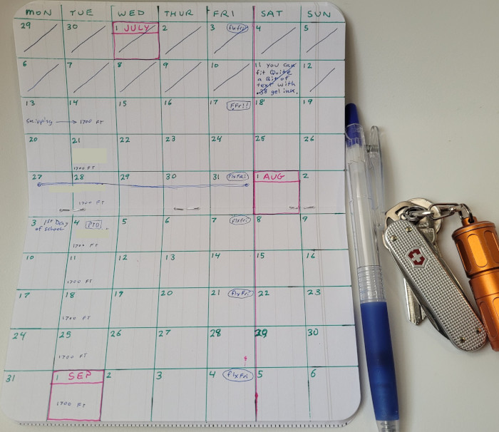 Photo of calendar spread along with pen and pocket items.