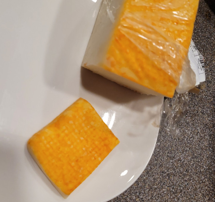 Photo of the cheese block with a slice.